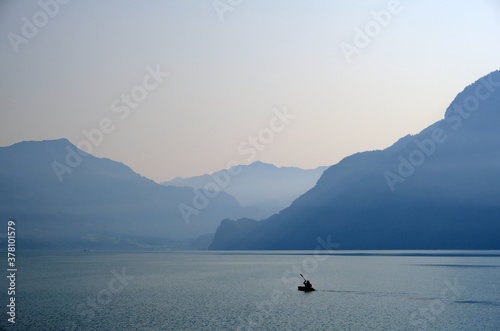 Single kayakker on Brienzersee lake near Interlaken, Switzerland, early morning
