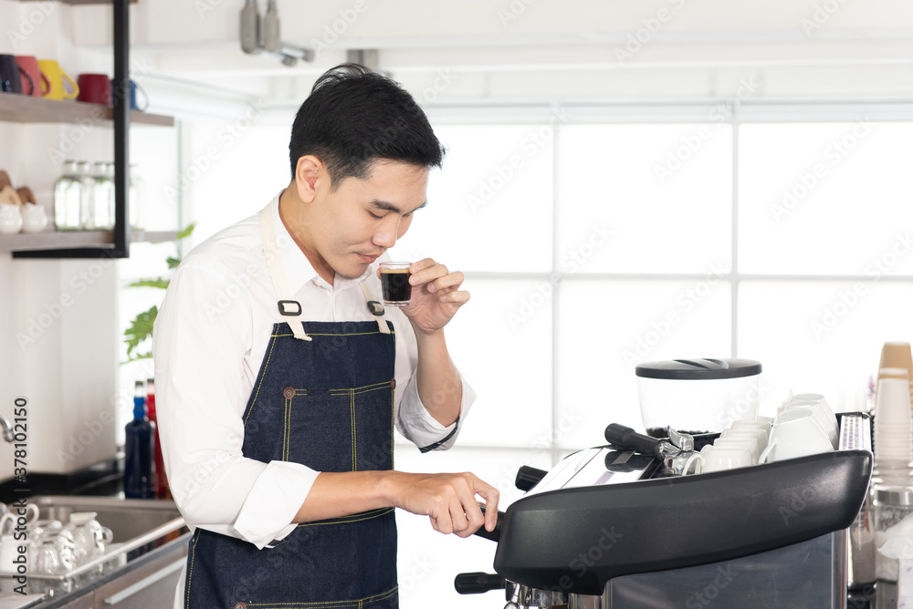 Asian barista man holding a cup of black coffee and smelling the black coffee, prepare to make coffee, serve customers in the coffee shop Asian barista man holding a cup of black coffee and smelling the black coffee, prepare to make coffee, serve customers in the coffee shop
