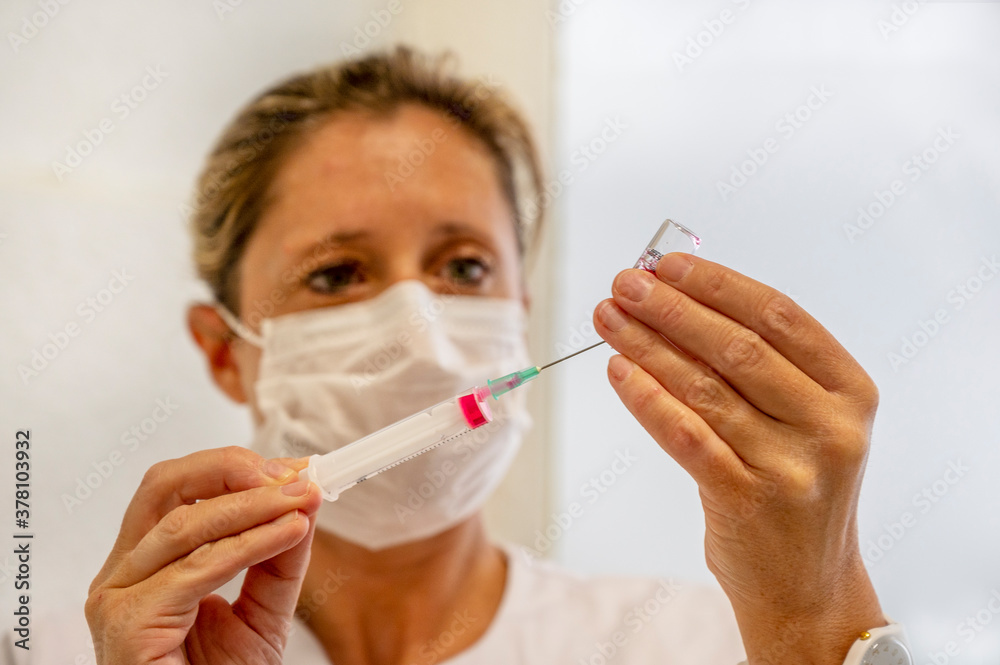 Jeune femme du personnel médical qui remplit une seringue avant injection Jeune femme du personnel médical qui remplit une seringue avant injection