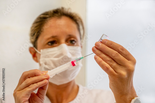 Jeune femme du personnel m  dical qui remplit une seringue avant injection