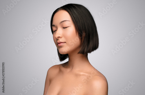 Asian woman with clean skin and closed eyes