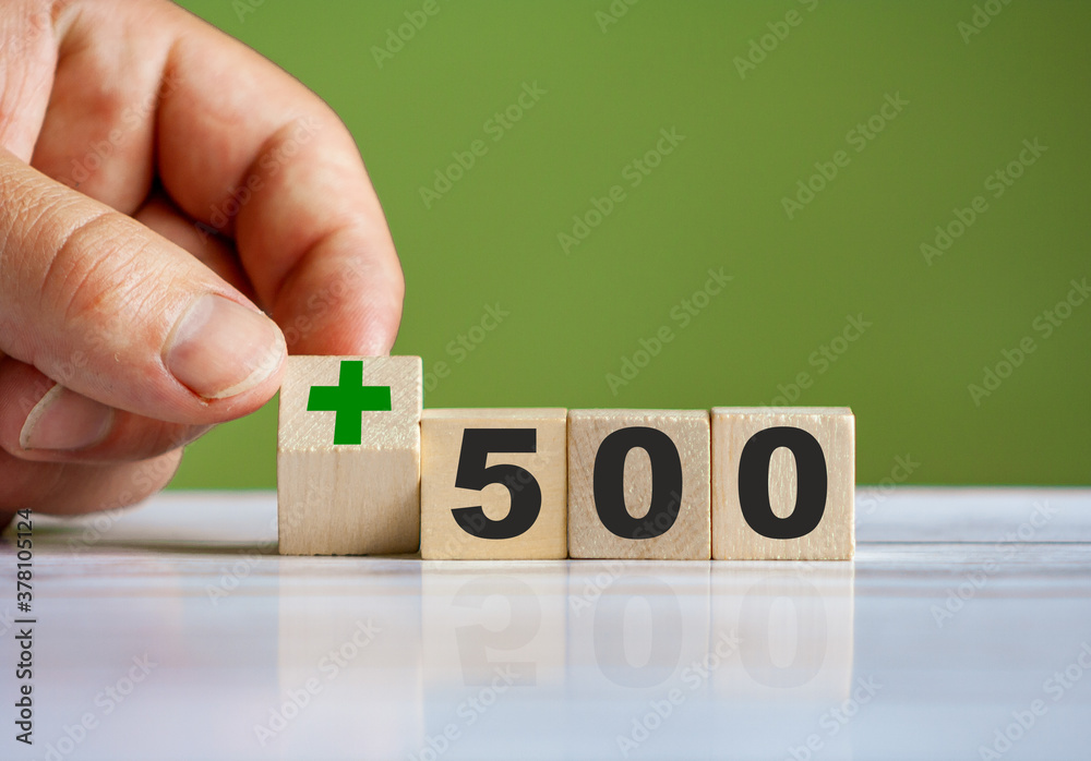 hand turn wooden block with plus sign and set text "+500" - obrazy, fototapety, plakaty 
