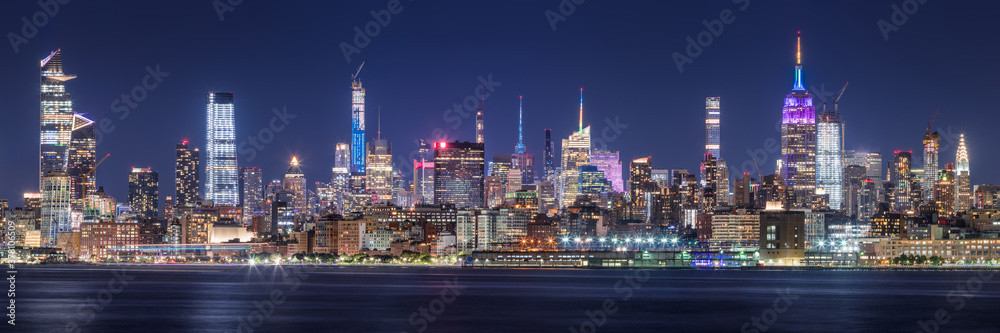 New York City panoramic cityscape of Midtown West skyscrapers at night along Hudson River Park. Manhattan, NY, USA