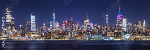 New York City panoramic cityscape of Midtown West skyscrapers at night along Hudson River Park. Manhattan, NY, USA