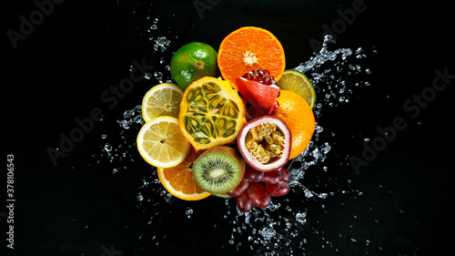 Freeze Motion Shot of Fresh Fruits with Splashing Water Isolated on Black Background.