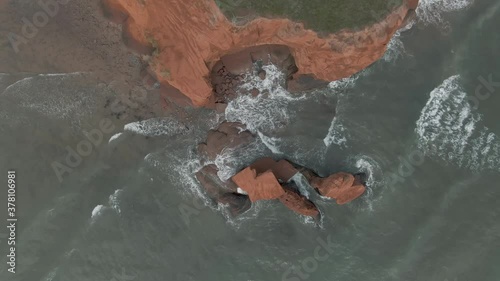 Waves Lap Gently On The Rocky Shoreline In Magdalen Islands, Quebec, Canada - aerial top-down shot