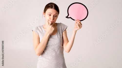 Surprised happy woman in shirt holding blank speech bubble