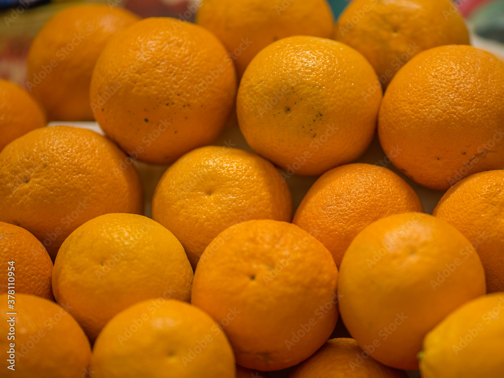 A pile of oranges sitting on top of a wooden table A pile of oranges sitting on top of a wooden table