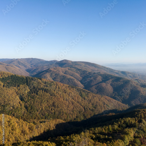Scenic view from the slope of the Kozara mountain overgrown with forest during a sunny day against the blue sky. © slobodan