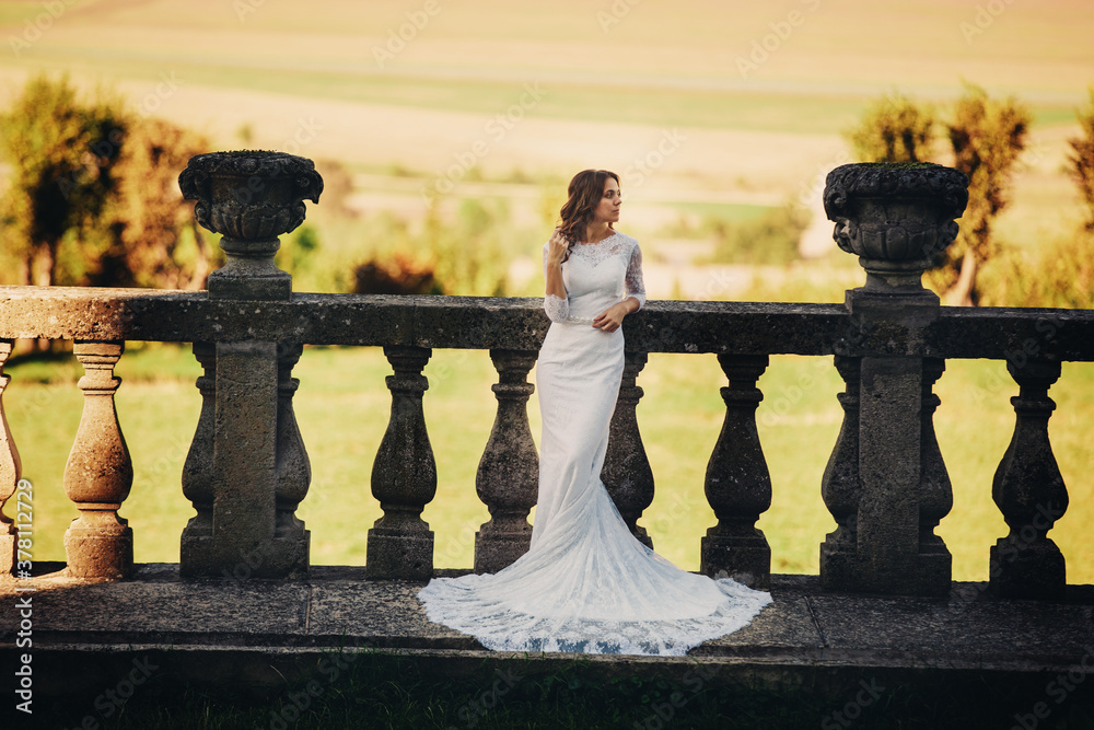 Beautiful bride in a luxurious dress standing on a large balcony