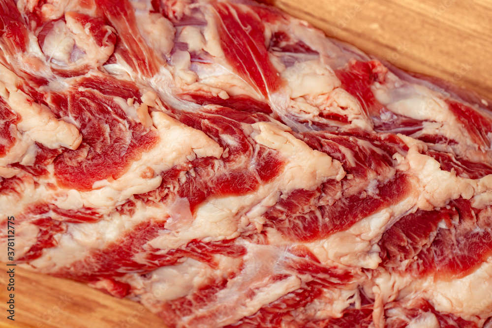 Fresh raw beef meat for steak on a wooden cutting board close-up. Close up view of a raw beef rib eye steak on a wood board. Fresh raw beef meat for steak on a wooden cutting board close-up. Close up view of a raw beef rib eye steak on a wood board.