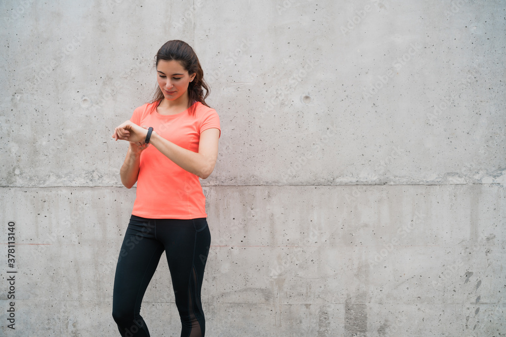 Fitness woman checking time on smart watch. Fitness woman checking time on smart watch.