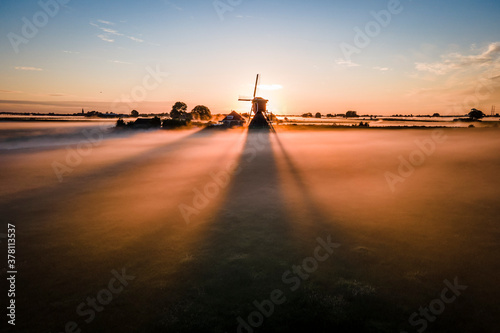 windmill in sunrise in the mist