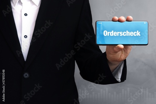 Orderscheck. Mann zeigt Telefon (Handy) mit Wort im Display. Weißer Text auf blau. photo