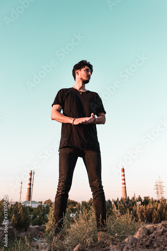 a young man in a black outfit in an industrial zone