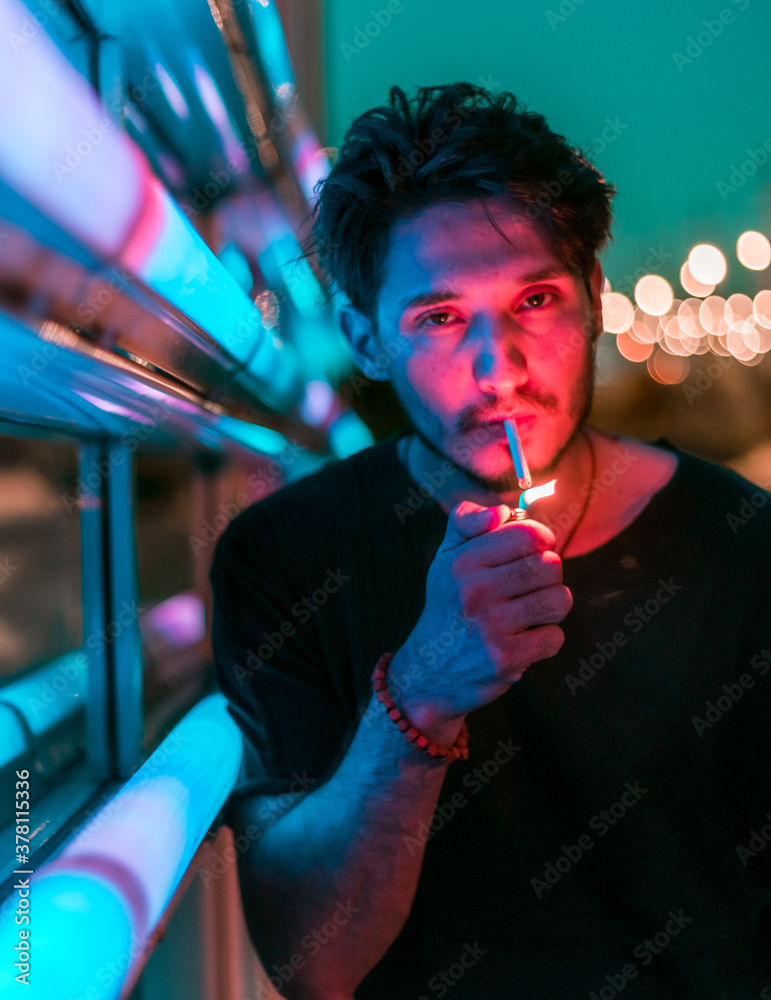 custom made wallpaper toronto digitala young handsome man leaning on the neon display at night and lighting a cigarette