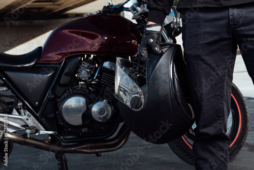 Motorcyclist holds a helmet in his hands