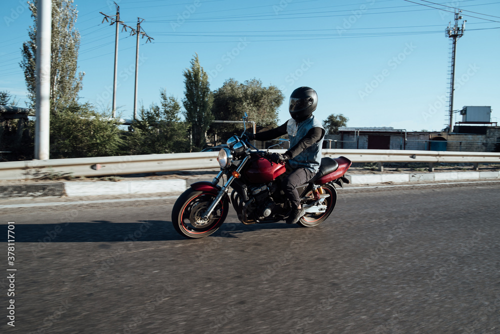 Man rides a motorcycle in the city.Motorcyclist riding a bike during the day on the road Man rides a motorcycle in the city.Motorcyclist riding a bike during the day on the road