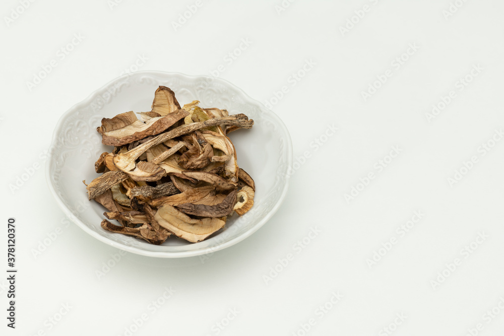 dried mushrooms in a saucer, on a white background dried mushrooms in a saucer, on a white background