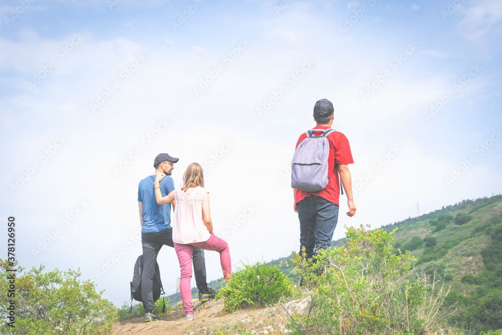 Three friends stands in nature and looks in different diections with green  nature and empty sky in the background. bank space image of lifestyle and people.