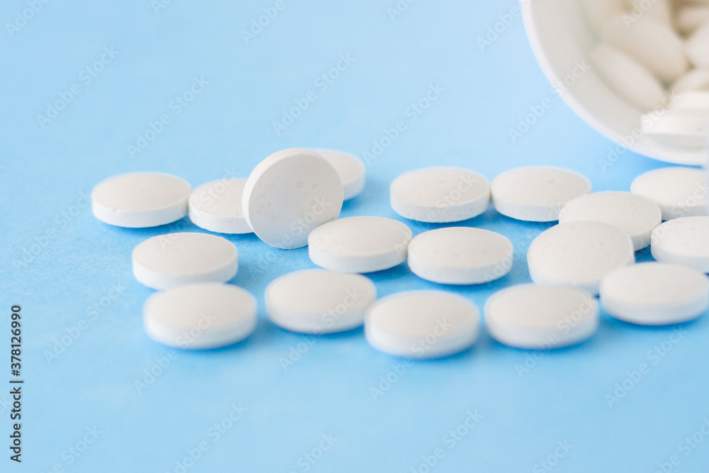 White homeopathic pills on a blue background. Close up