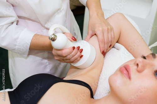 The procedure of cavitation on the hand of a young woman for the beauty and slenderness of her hands.