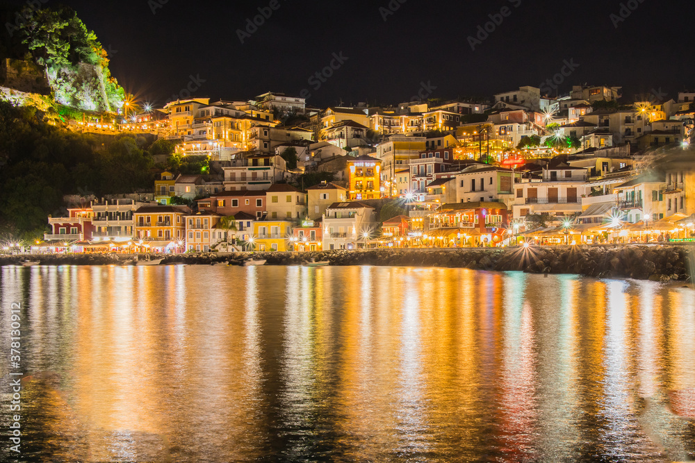 Night panorama or nightscape of the city of Parga, Greece. Looking across the bay towards traditional houses and syvota castle.