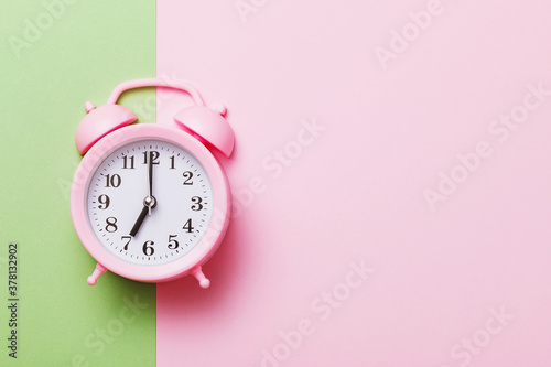 Pink alarm clock on a colored background with copy space