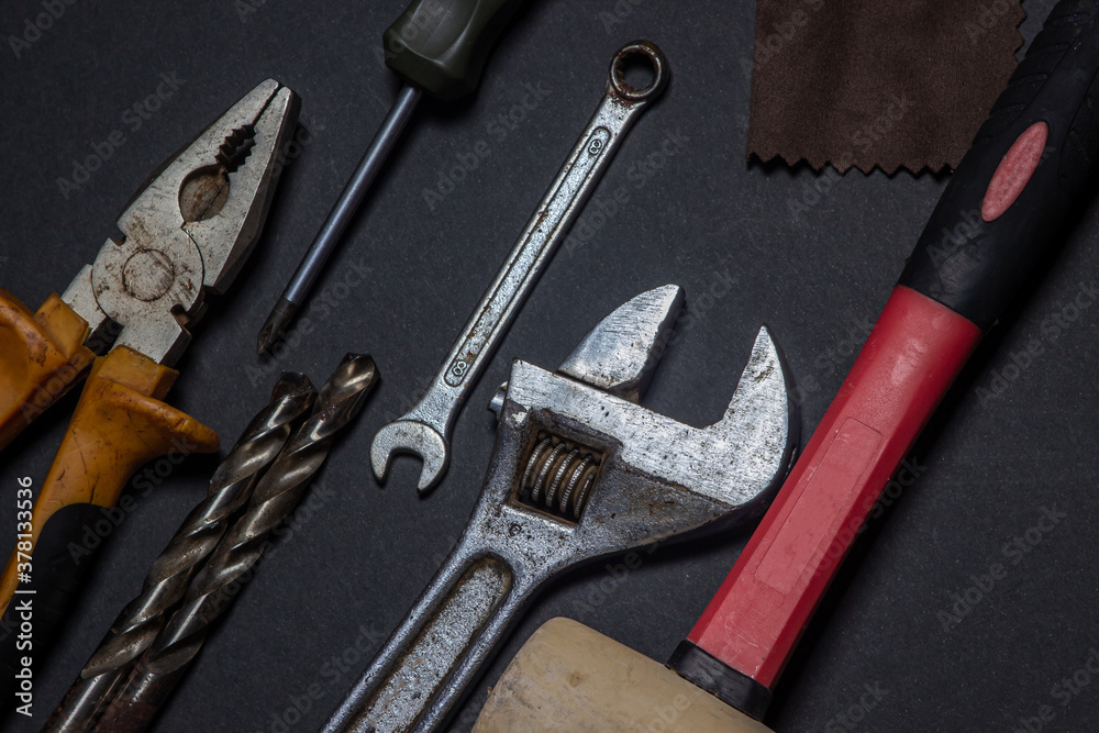 Working tools on a black background. Used and dirty work tools for home improvement or diy repair projects. Manual labor concept. 