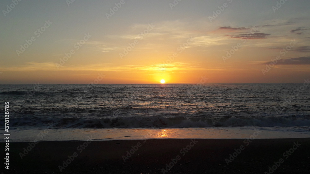 Sonnenuntergang mit kleinen Wellen am feinen Sandstrand von Kalabrien 