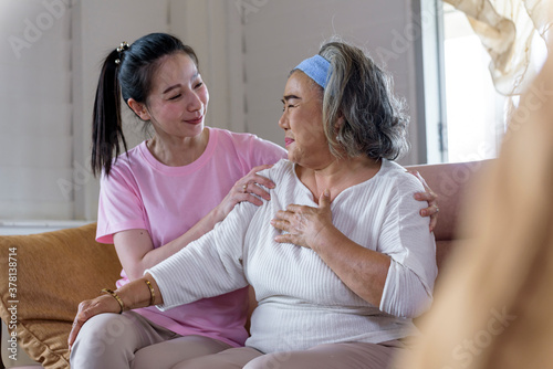 Asian young woman take care and  support with hug, that make feel good and smile older mother in living room. family concept