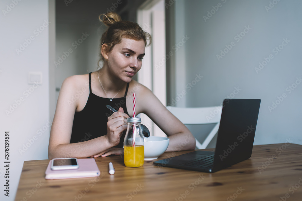 Concentrated woman eating and surfing laptop Concentrated woman eating and surfing laptop