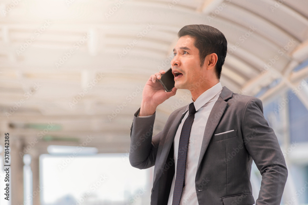 Confused businessman in suit talking on smartphone. Confused businessman in suit talking on smartphone.