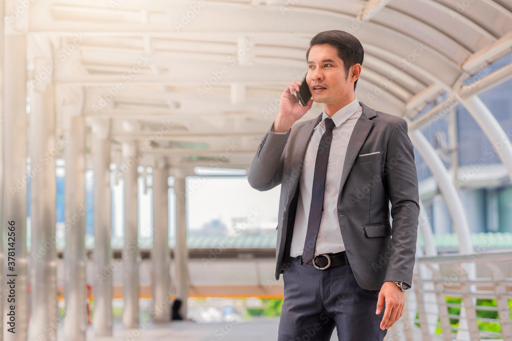 Successful asian businessman in suit speaks on phone and smiles. Concept of conversation. Copy space