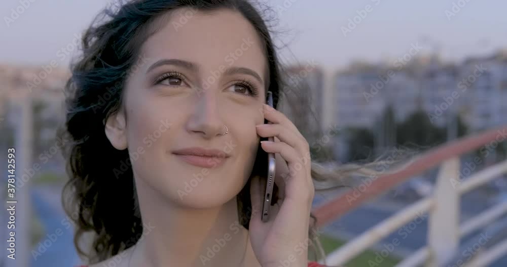 Young beautiful girl is speaking phone on seaside afternoon time. Student's phone call. Young beautiful girl is speaking phone on seaside afternoon time. Student's phone call.