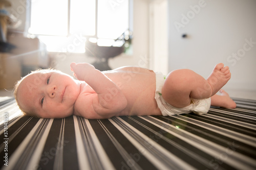 Bild auf Leinwand A newborn baby in a diaper lying on a made-up bed