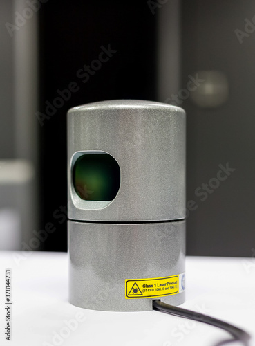 A rotating liDAR sensor with cable on a bench prior to installation in a vehicle. photo