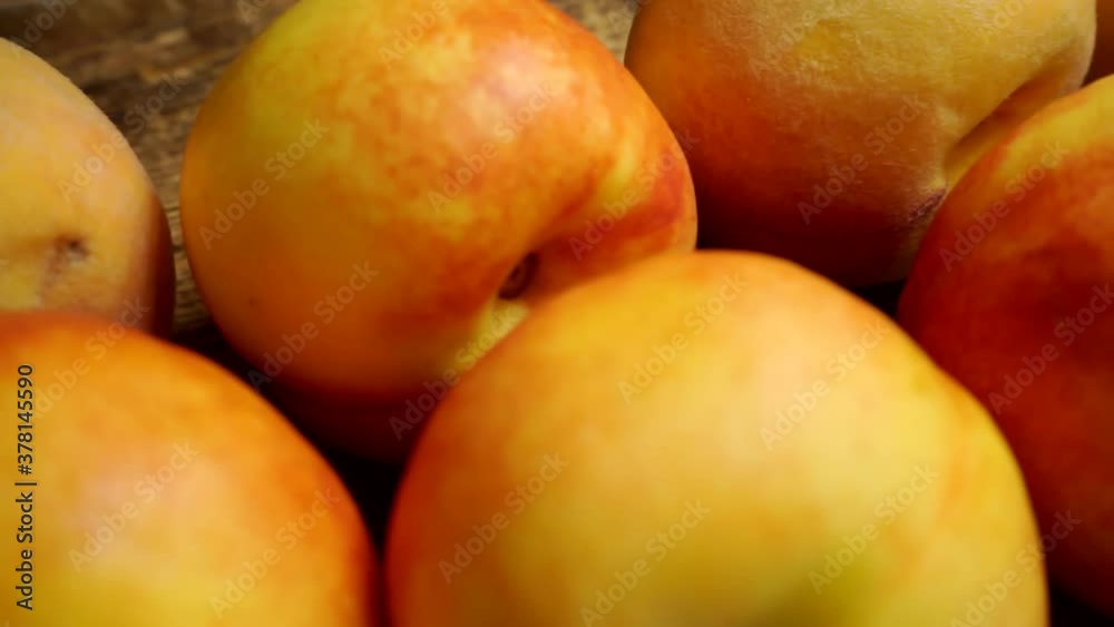 ripe juicy bright peaches and nectarines lie on a wooden table. ripe juicy bright peaches and nectarines lie on a wooden table.