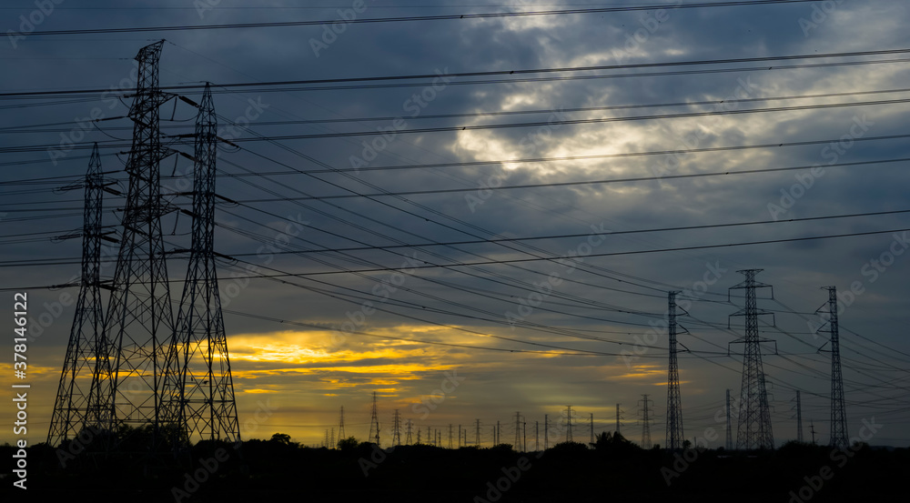 silhouette Electric transmission pole with sunset in the sky
