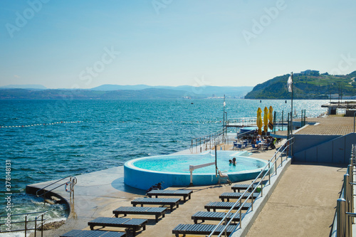 Weekend vibes and summertime refreshment in the open swimming pool next to the beach of Adriatic sea in Isola resort, Slovenia