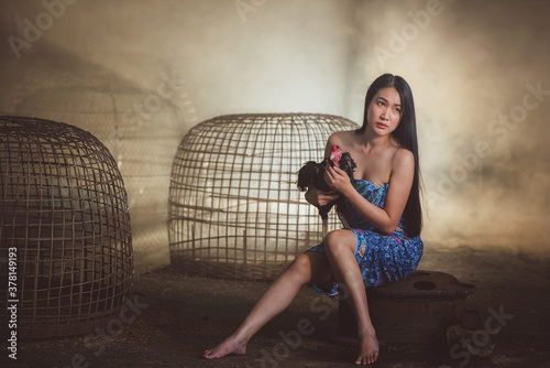 Beautiful Thai women dressed in a unique Thai traditional sarong. A beautiful and sexy woman wearing sarong is about to bathe her chicken. photo