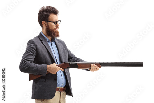 Bearded man aiming with a shotgun photo