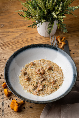 Top view of creamy mushroom risotto in a restaurant, with white wine added, food styling with ingredients around