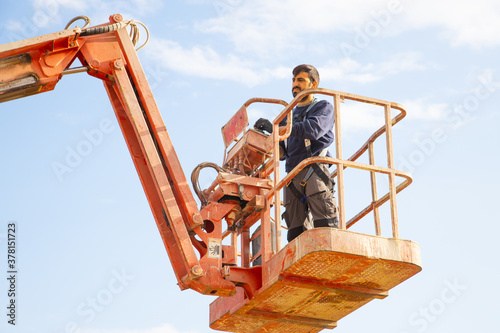 Obraz na płótnie man working at heights with lifting platform. w salonie