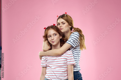 Cheerful mom and daughter joy lifestyle studio pink background family