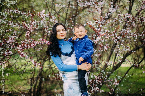 Mother and son are in blooming garden. © Stanislav