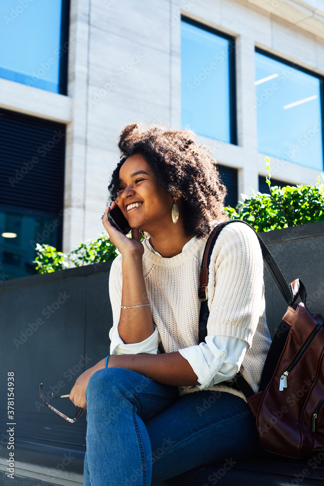 young pretty african girl posing cheerful on city background, lifestyle outdoor people concept