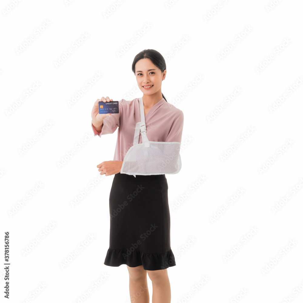 Beautiful young asian woman patient to arm broken and put on arm sling with showing holding credit card with happy and smile isolated on white background. Healthcare and finance concept. Beautiful young asian woman patient to arm broken and put on arm sling with showing holding credit card with happy and smile isolated on white background. Healthcare and finance concept.