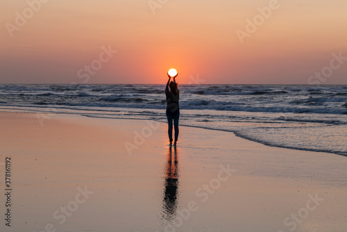 Woman holding the sunset
