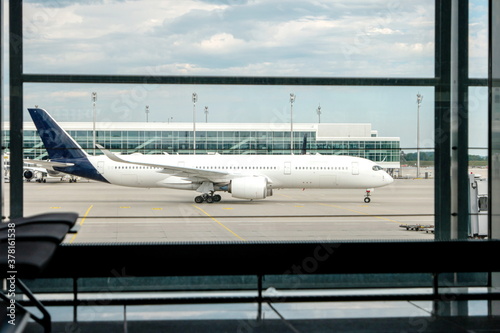 Generic regional flight airplane as seen from inside generic international airport terminal taxi towards runway